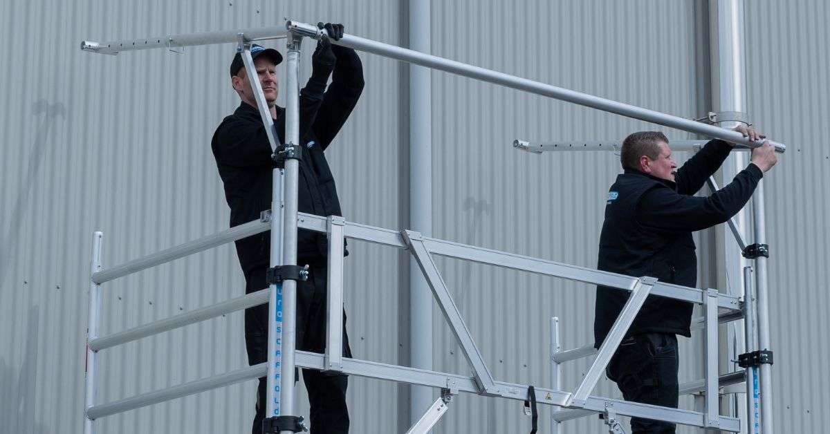 hombres montando un andamio de torre